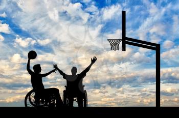 Disabled sportsman in wheelchair play basketball on basketball court with ball day. Concept sport and willpower