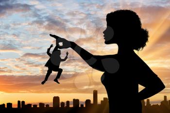 Silhouette feminist holds in his hand the little man against the backdrop of the cityscape. Concept of feminism.