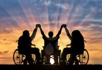 Disabled in wheelchair holding hands sunset. Concept happy disabled