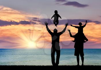 Concept of gay parents. Silhouette of happy gay parents with children on the background of sea sunset