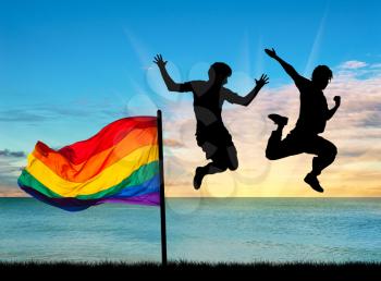 Concept of gay people. Silhouette of two happy gays jump with a flag at sunset 