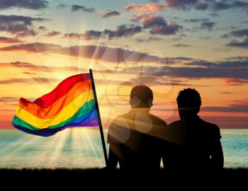 Concept of gay people. Silhouette of two gay men resting on a background of blue sea and sky