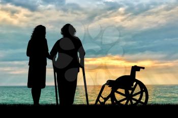 Silhouette of a disabled wheelchair near the peepers and near sea. The concept of a disabled person and the home for elderly