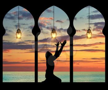 Concept of the Islamic religion. Silhouette of praying Muslim at the background of the sea sunset
