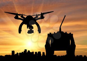 Silhouette flying reconnaissance drone over city and hand remote control. Concept of military intelligence and information