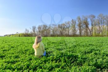 Concept of outdoor fun. Young woman resting on the green grass in the meadow