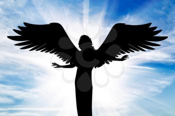 concept of religion. Silhouette of a beautiful angel with wings in the rays of light on the background of the sky