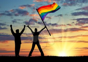 Silhouette of two happy gays in nature and the rainbow flag in hand at sunset