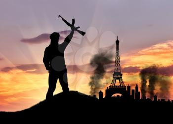 Concept of terrorism. Silhouette of the terrorist and the city in smoke against the sunset