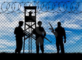 Concept of war. Silhouette of military guards near the fence and watchtower