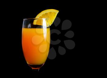 Mimosa cocktail with a slice of orange on a black background closeup