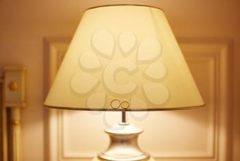 Wedding accessories and decorations. Wedding rings lie on a floor lamp