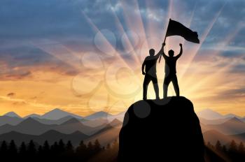 Silhouette of two climbers on a mountain top with a flag in his hand. success concept