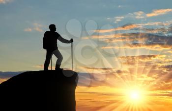 Silhouette of a climber on top looks into the distance. Concept effort and objectives