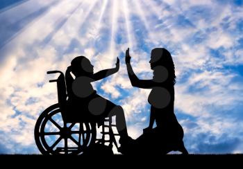 Silhouette of a happy disabled child girl sitting in a wheelchair doing hand gesture, give five to her mom. The concept of support for children with disabilities