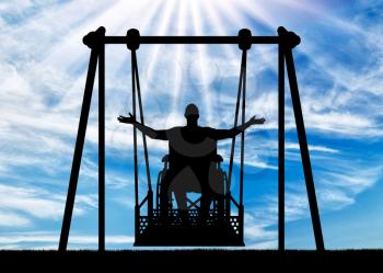 Silhouette of a happy man is a disabled person in a wheelchair on an adaptive swing for disabled people. Concept of the lifestyle of people with disabilities