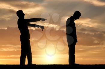 A silhouette of a man showing a finger at another man telling him that he is a loser. The concept of social problems in society