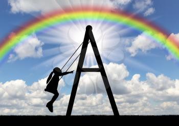 A girl child is rolling on a swing against the sky with a rainbow. Concept of a happy childhood