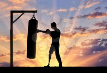 Silhouette of a disabled man with a leg prosthesis, engaged in boxing. The concept of disabled people leading an active lifestyle