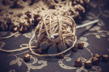 A ball of linen yarn and a crochet hook. Photo toned.