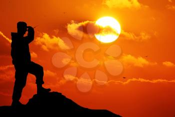 Silhouette of soldier with rifle against a sunset