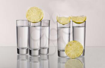 Three gold tequila shots with lime isolated on white background