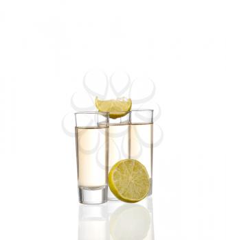 Three gold tequila shots with lime isolated on white background