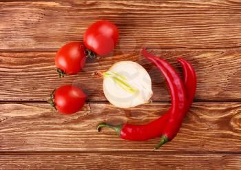 Red hot cherry and chili peppers over white wooden background onion 