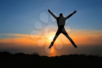 silhouette of man on the sunset on rock