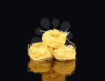  raw dry nest pasta with reflection  on black