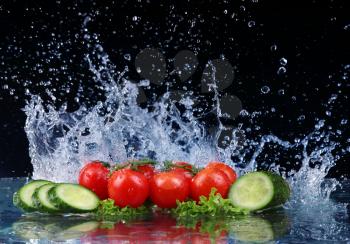 Salad, tomato and cucumber with water drop splash