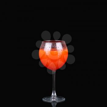 a glass of grapefruit juice on a black background