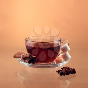 Cup of tea on glass with orange background