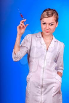 Doctor, girl, syringe injection. Nurse. Portrait of young woman in doctor's smock and with syringe.