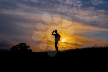 Follow your dreams, silhouette of man at sunset. Hiker with backpack walking in the field. Over sunset. Summer healthy active lifestyle. Single travel.