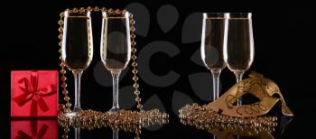 set of Carnival mask and glasses with champagne on a dark background