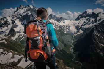 Woman hiking around mountains at spreeng time. Dombai, Karachay-Cherkessia, Russia