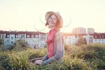 Beautiful young woman enjoying the sunset on top of a hill. Idea of rest and relaxation