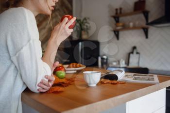 Autumn sseries in the Kitchen, melancholy and warm.. Relaxing in cold weather. red-haired girl enjoying apples in the kitchen