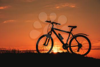 Silhouette of a male mountainbiker at sunset in the mountains. The idea and concept of a healthy lifestyle, outdoor activities and sports
