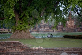 Back view of a asian couple watching sun on the park in Sukhothai, Thailand. in Sukhohai Historical Park, Thailand