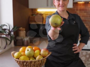 Healthy eating lifestyle concept portrait of beautiful young redhair woman preparing tasty food, holds out an apple