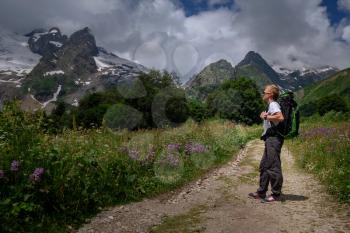 Man with backpack hiking in mountains. Travel Lifestyle success concept, adventure active vacations outdoor , mountaineering sport in North Caucasus, Dombai, Karachay-Cherkessia, Russia