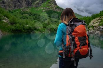 Traveler look at the mountain lake. Travel and active life concept. Adventure and hiking in the mountains region in the North Caucasus, Dombai, RussiaNorth Caucasus, Dombai, Russia