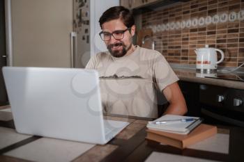 young man having video call via computer in the home office. Virtual house party. Online team meeting video conference calling from home, communication with family and friends