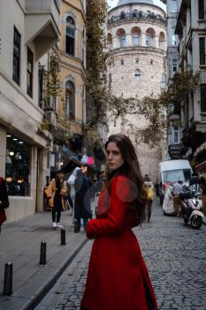 Portrait of beautiful woman with view of Galata tower in Istanbul, Turkey. Travel and vacation in Turkey concept