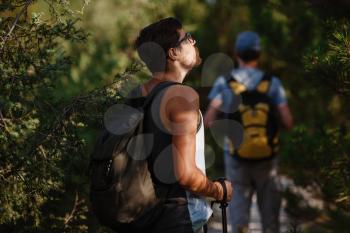 Two hikers men walk on trek in mountain. Trekking in mountains. Hills and mounts in sport tourism. enjoying adventure. Hiker in background.