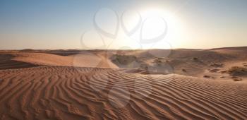 Sunset over the sand dunes in the desert. The ghost town of Al-Madam is about 60 km from Dubai City. united arab emirates. The concept of global warming