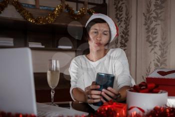 Christmas online shopping, work and education. Woman with notebook computer at home in Santa hat. Winter holidays sales, Remote Christmas video party. Family quality time during pandemic.