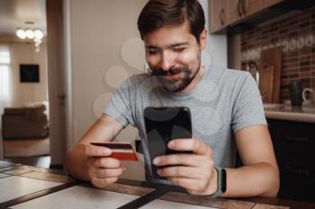 hipster young man shopping online with credit card using smart phone at home. Indoor. online shopping concept.